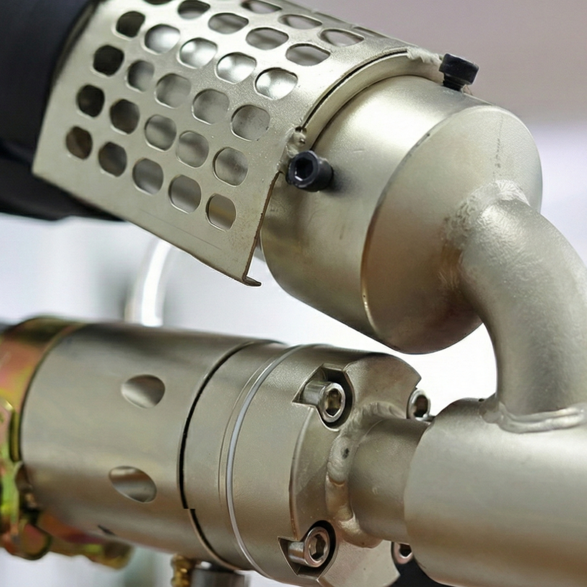 Close-up of the barrel and rotating nozzle of a manual extrusion welder, showing the heating system for high-strength plastic welding in industrial repairs.
