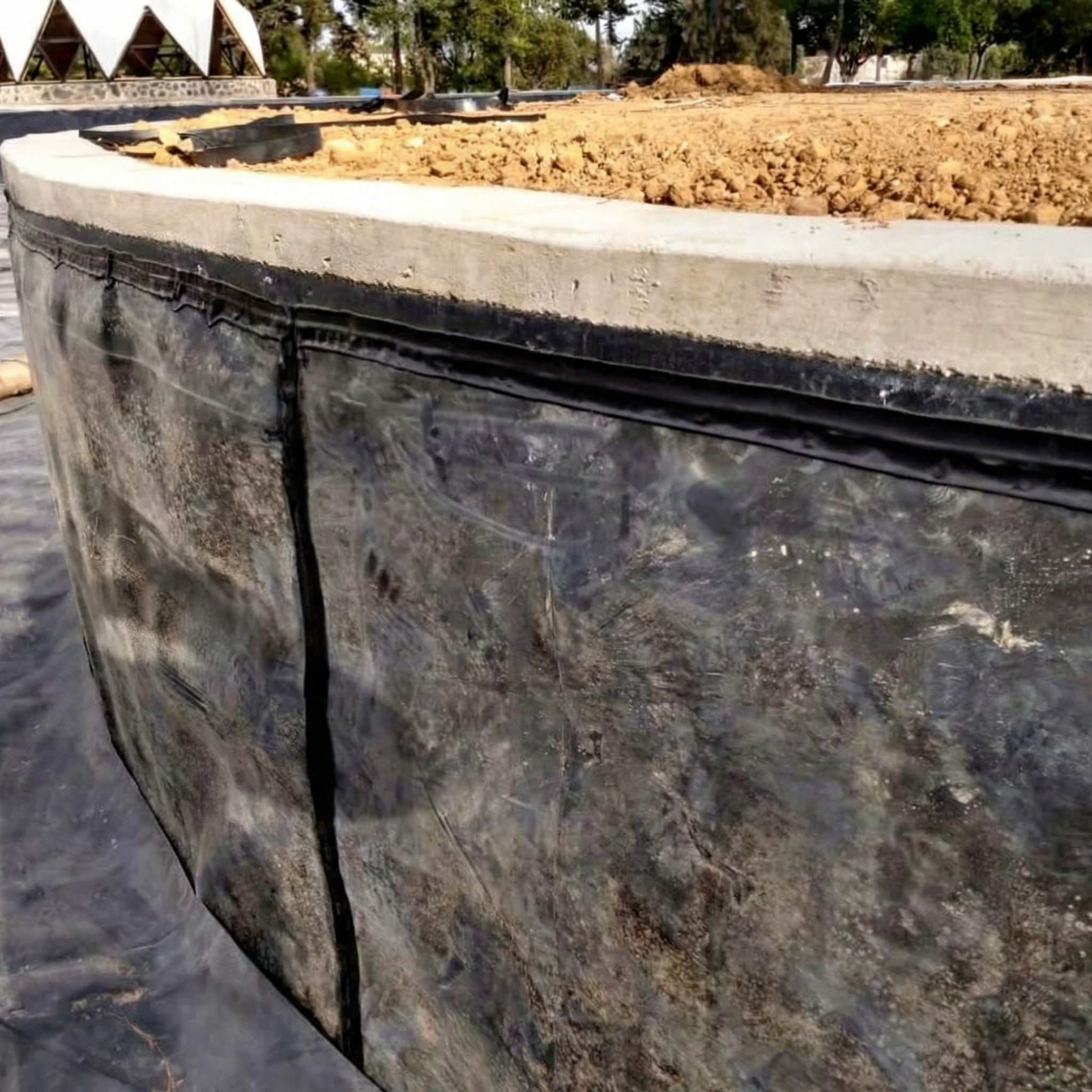 Installation of a poly lock profile on a concrete wall to secure a geomembrane in waterproofing projects in the Dominican Republic.