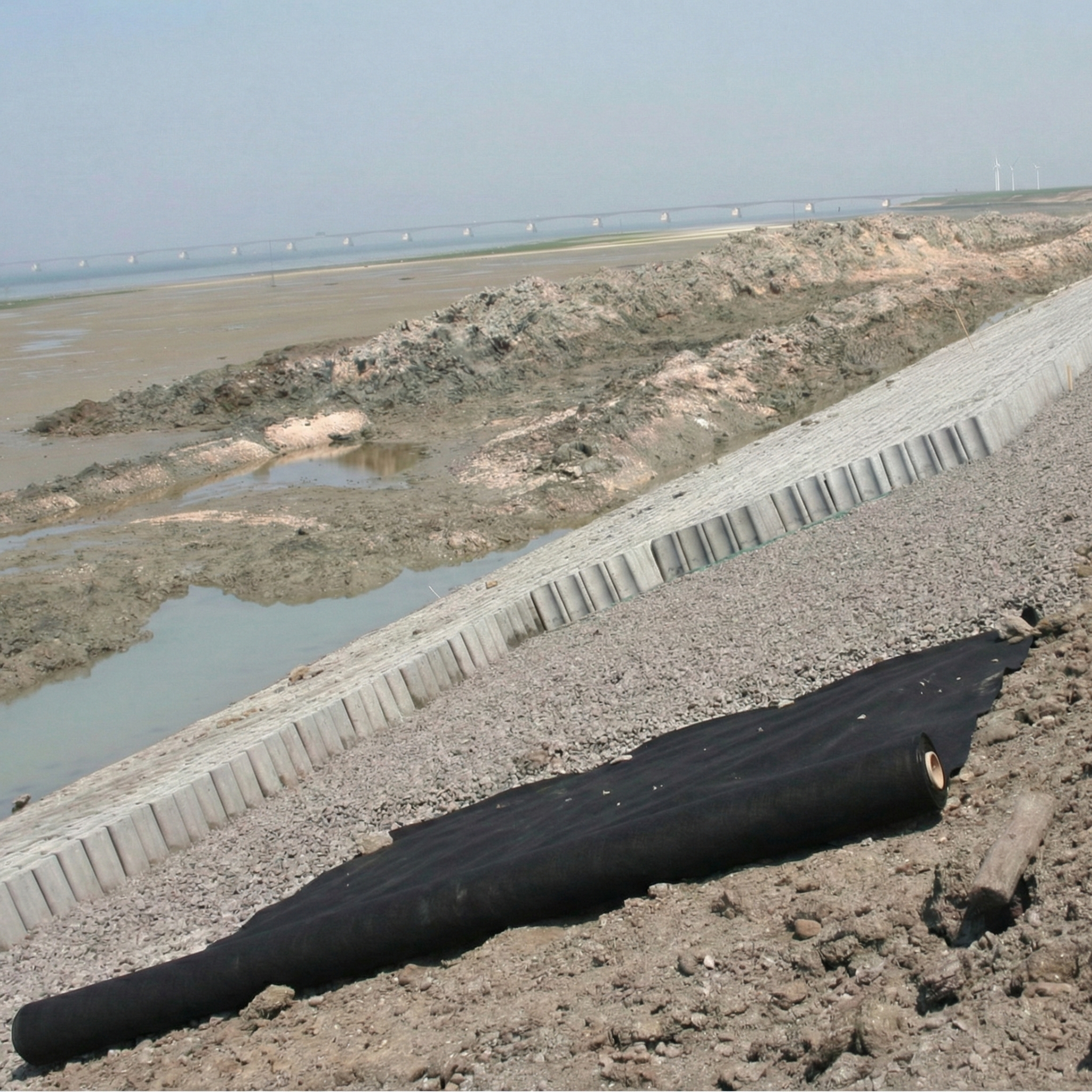 Geotextil no tejido de polipropileno (PP) negro instalado en obra para separación de suelos y protección de geomembranas.