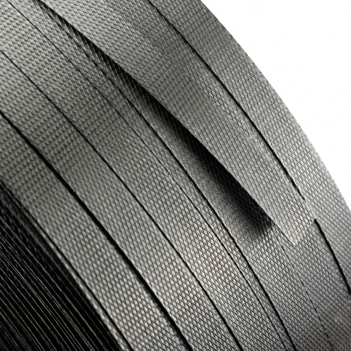 Roll of black reinforced polypropylene strap or PP strapping, industrial material ideal for cargo lashing, load securing, and transport logistics.
