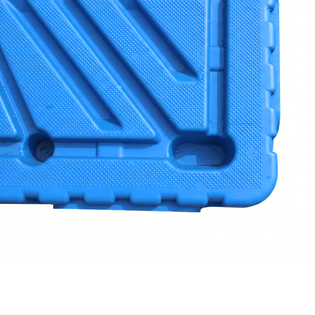Detalle de la base reforzada de un pallet plástico reversible azul de doble cara para uso intensivo en almacén.
