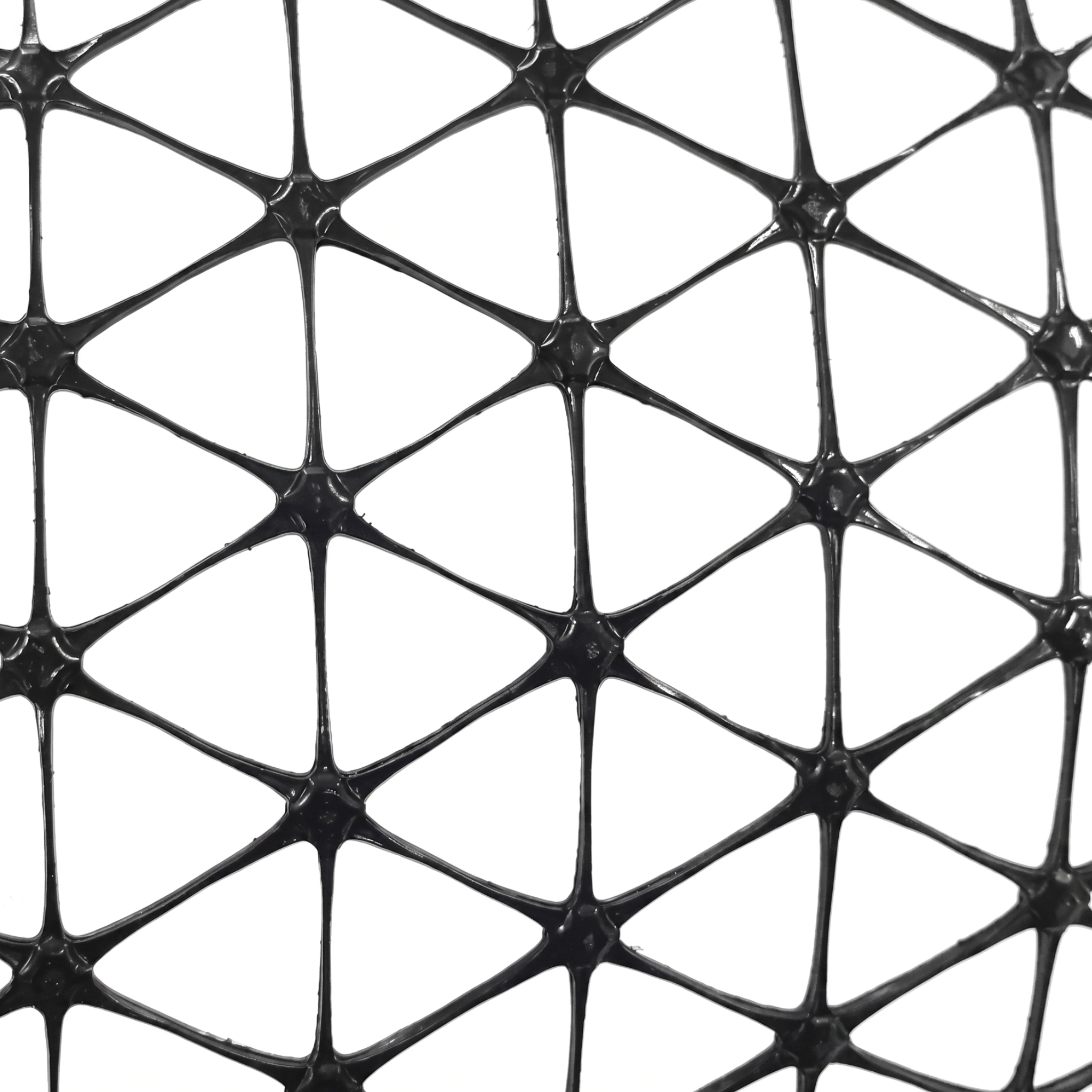 Detail of the triaxial structure of the PP geogrid, optimizing load distribution on the ground.