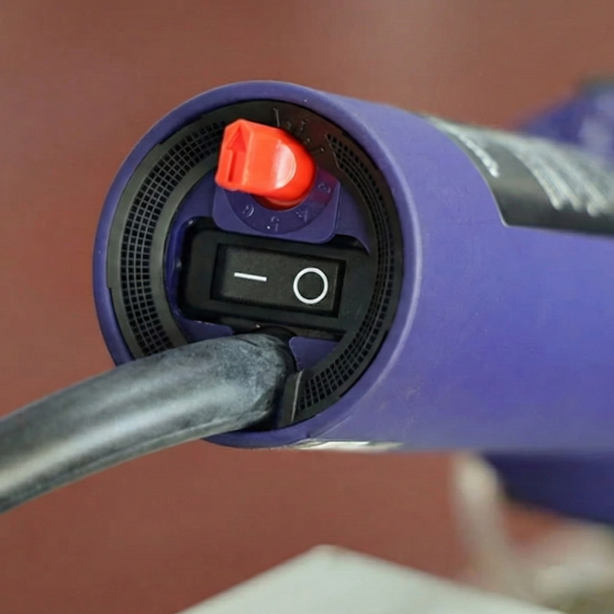 Close-up of the grip handle with ON/OFF switch on a manual thermofusion welding tool, providing operational control.