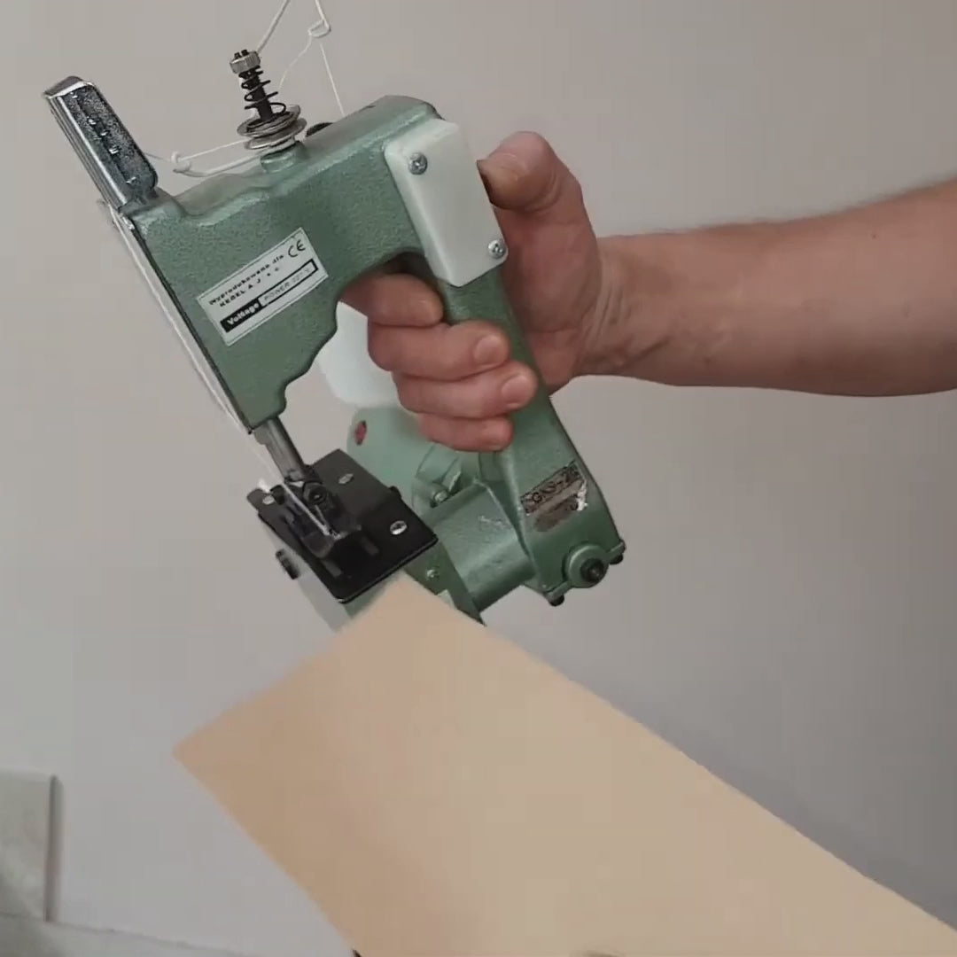 Mini máquina de coser portátil eléctrica funcionando