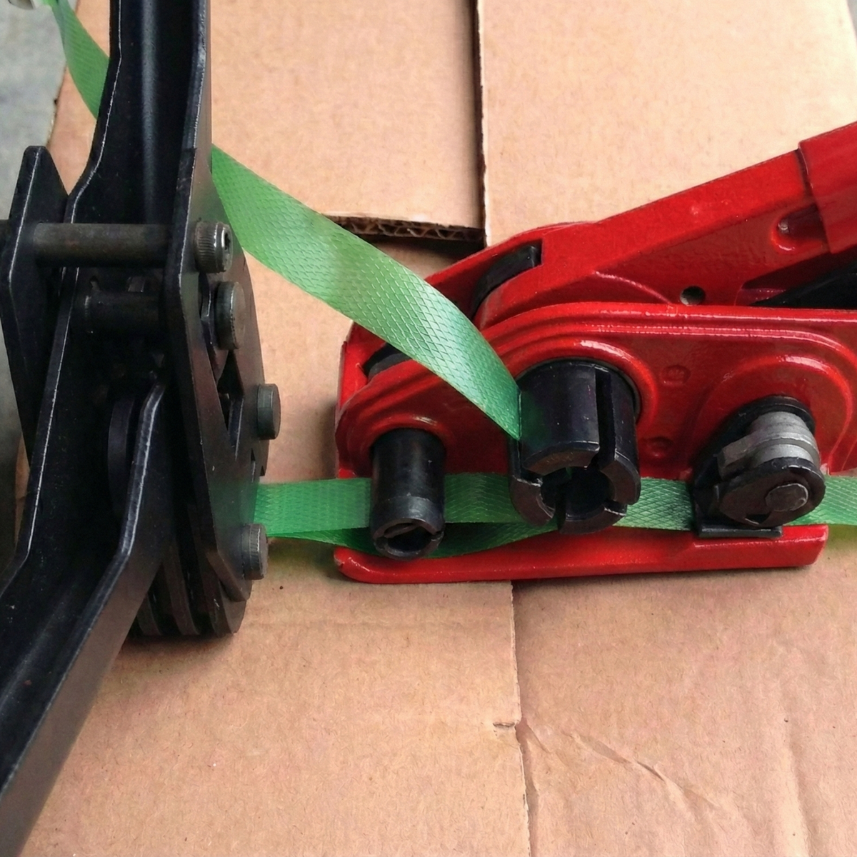 Demonstration of box strapping using packaging tools and plastic straps.